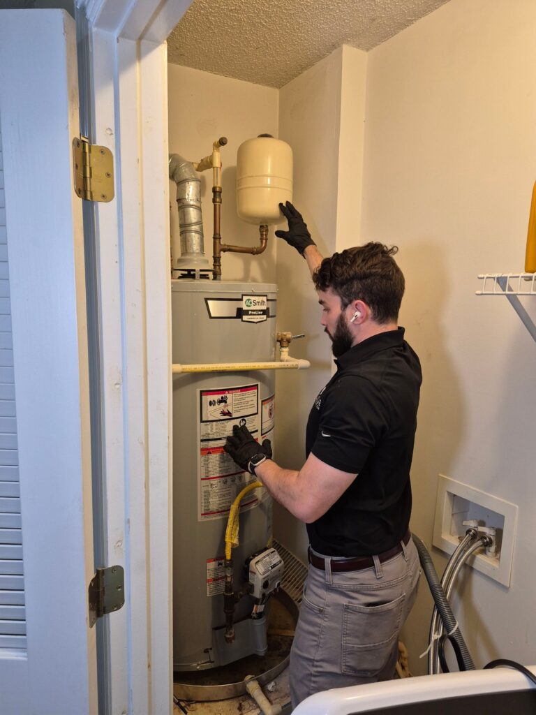 A restoration professional inspecting a water heater.