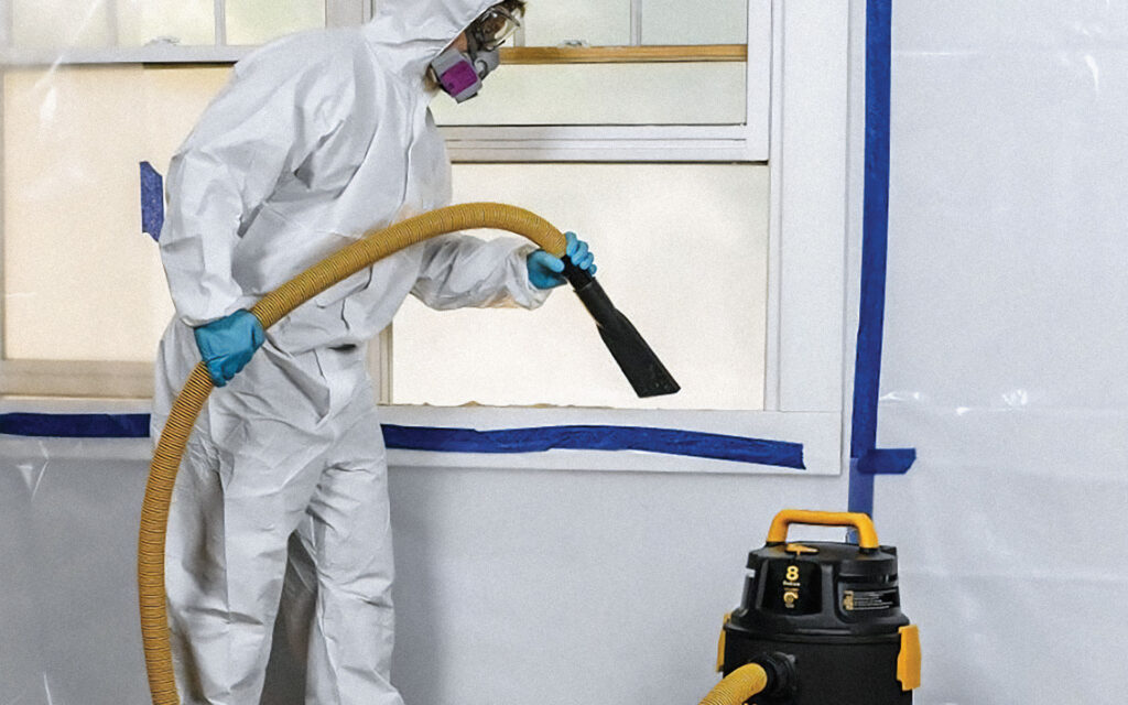Certified technician wears personal protective equipment and uses HEPA vac during mold remediation process